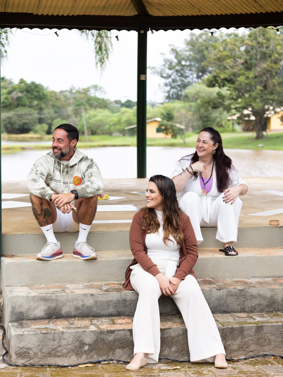 Participantes sentadas nos degraus à beira de um lago